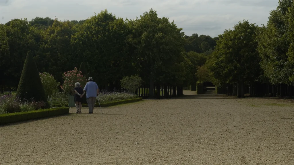 Un couple de marcheurs âgés dans une allée de parc