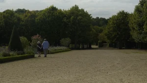 Un couple de marcheurs âgés dans une allée de parc