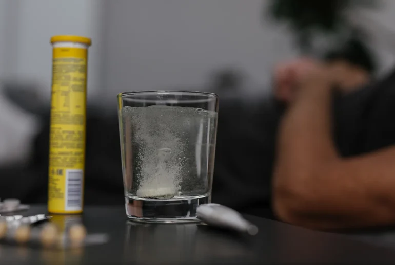 Verre d'eau et médicaments sur une table